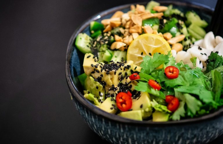 Bunte Schüssel mit Avocado, Gurke, Chili, Koriander, Zitrone und Sesam.